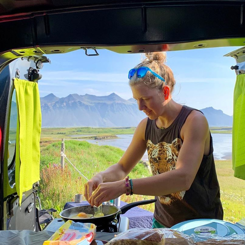 girl cooking eggs in a campervan